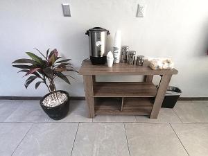 a table with a coffee maker and a potted plant at Hotel HCM Guadalajara in Guadalajara