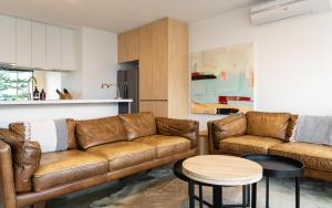 a living room with two brown leather couches and a table at Aquabelle Apartments in Rye