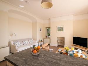 a living room with a table with a bowl of fruit at The Patio Flat in Bodmin