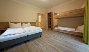 a bedroom with two bunk beds and wooden floors at Holiday Lodge Central in Saalbach-Hinterglemm