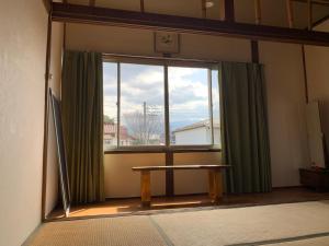 a room with a window with a wooden table in front of it at Guesthouse Honobono in Fujikawaguchiko