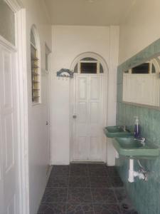 une salle de bain avec deux lavabos et une porte blanche dans l'établissement Casa Cora Oaxaca Hospedaje Familiar Guesthouse Casa de Huespedes, à Oaxaca