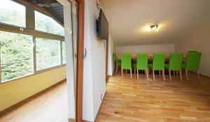 una sala de conferencias con sillas verdes y TV de pantalla plana en Holiday Lodge Central, en Saalbach Hinterglemm