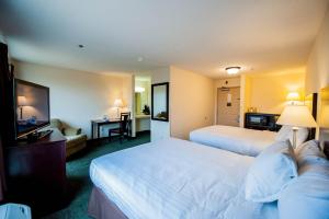 a hotel room with two beds and a television at Greystone Inn & Suites in Vance