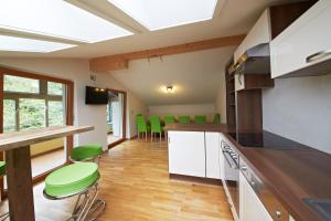 a kitchen with green chairs and a counter top at Holiday Lodge Central in Saalbach-Hinterglemm