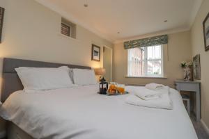 ein Schlafzimmer mit einem großen weißen Bett und einem Fenster in der Unterkunft Grays Cottage in Whitby