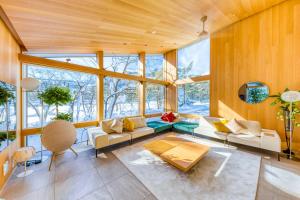 a living room with wooden walls and windows at JADE Amber Resort Hakuba in Hakuba