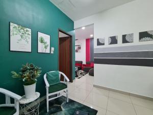 a waiting room with a green wall and a waiting roomasteryasteryasteryasteryastery at Embon Homestay in Padang Serai