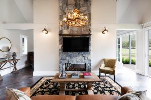 sala de estar con chimenea y TV en Brokenback Views Country Estate Hunter Valley en Pokolbin