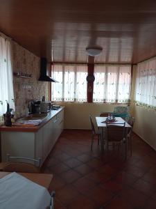 a kitchen and dining room with a table and chairs at Casa Ecaterina 2 Mai in 2 Mai