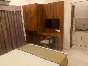 a bedroom with a bed and a tv and a desk at Hotel Mumbai House-LIG Behind CHL Hospital in Indore