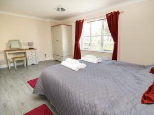 a bedroom with a bed with two towels on it at Glyn Cottage in Llanon