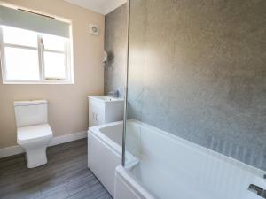 a bathroom with a tub and a toilet and a shower at Glyn Cottage in Llanon +14 photos