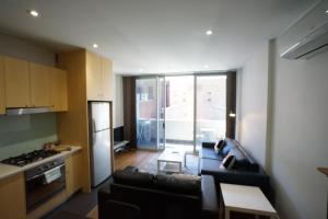 uma sala de estar com um sofá e uma cozinha em Bent St Apartments em Adelaide