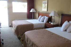 ein Hotelzimmer mit 2 Betten und einem Fenster in der Unterkunft Sunset Inn - Augusta in Augusta
