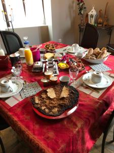 une table avec un tissu de table rouge et de la nourriture dans l'établissement LES ANDALOUSES, à Avèze