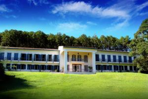 a large white building with a grass field at Hotel Fazenda Dona Carolina in Itatiba