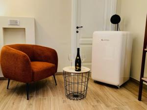 una sala de estar con una silla y una botella de vino en Agriturismo Le Fornase, en Castelnuovo del Garda