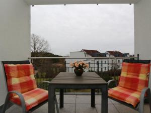een tafel en 2 stoelen met een vaas op een balkon bij Residenz Bellevue Fewo 36 Fewo cc Herrmann in Zinnowitz