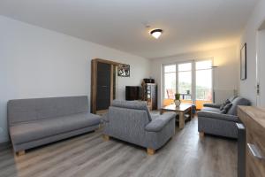een woonkamer met 2 banken en een tv bij Residenz Bellevue Fewo 36 Fewo cc Herrmann in Zinnowitz