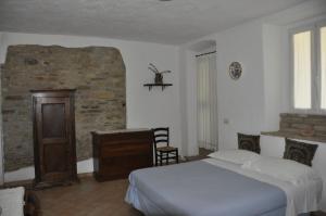 a bedroom with a bed and a stone wall at Fattoria di Rigone in Coltavolino