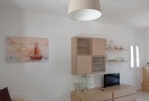a living room with a painting of a boat on the wall at Hermes Resort in the Port of Sivota in Sivota