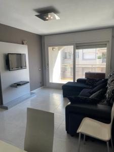 a living room with a couch and a tv at Ideal apartamento a 100m playa - Calafell in Calafell