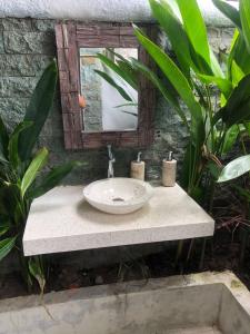 a bathroom with a sink and a mirror at Alamanda Bingin in Uluwatu