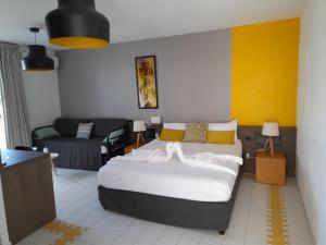 Un dormitorio con una cama grande y un sofá. en Studio 25 m Manganao Joela 4 personnes avec machine a laver, en Saint-François