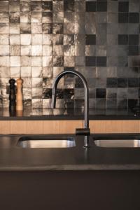 a kitchen counter with a sink and a black counter top at Vakantiehuis Spoor 74 in Diksmuide