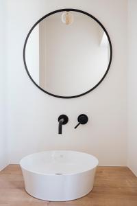 uma casa de banho com um lavatório branco e um espelho. em Vakantiehuis Spoor 74 em Diksmuide