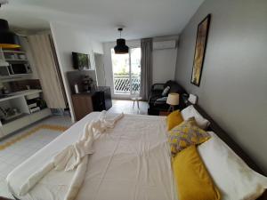 ein Schlafzimmer mit einem weißen Bett und ein Wohnzimmer in der Unterkunft Studio 25 m Manganao Joela 4 personnes avec machine a laver in Saint-François