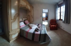 ein Schlafzimmer mit einem Bett mit einem Holzrahmen in der Unterkunft Gîte, suite d'hote de charme, petit déjeuner compris in Firmi
