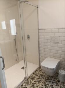 uma casa de banho com um WC e uma cabina de duche em vidro. em Casa Portoblau em Porto Cristo