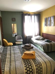 una camera d'albergo con due letti e una finestra di LES ANDALOUSES ad Avèze