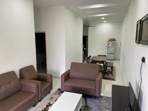 - un salon avec deux chaises et une table dans l'établissement Maryam Homestay, à Jertih