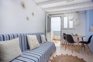 a living room with a couch and a table with chairs at Haraki Bay Loft (by haris) in Haraki