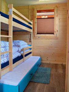a bunk bed room with two bunk beds in a cabin at Domki Letniskowe ARTEMI in Rowy