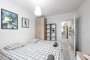 a white bedroom with a bed in a room at Pokoje Wita Stwosza in Warsaw