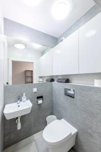 a bathroom with a white toilet and a sink at Pokoje Wita Stwosza in Warsaw