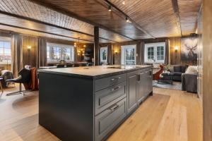 a kitchen with an island in the middle of a room at Skeikampen cabin with mountain view, jacuzzi, and 8 bedrooms in Aulstad