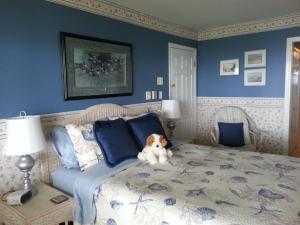 un osito de peluche sentado en una cama en un dormitorio en Hammond Bay Oceanside Guesthouse, en Nanaimo