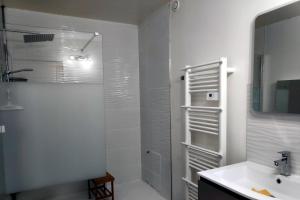 a white bathroom with a shower and a sink at La Peyrova in Saint-Sulpice-les-Feuilles
