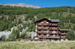 a hotel on a hill with a mountain at Hotel Vallée De Cogne in Cogne