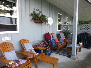 een groep stoelen op de veranda van een huis bij Hammond Bay Oceanside Guesthouse in Nanaimo +15 foto's
