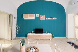 a room with a blue wall and a desk at Il Riccio Apartment 28 in Procida