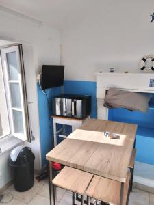 Cette chambre est dotée d'une table en bois et d'un mur bleu. dans l'établissement GITE ENTRE TERRE ET MER, à Mareuil-sur-Lay