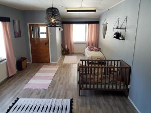 a baby room with a crib and a door at Inha holiday house in Ähtäri