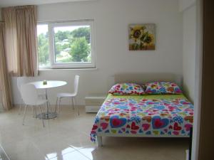 1 dormitorio con cama, mesa y ventana en Apartments Tomo, en Hvar