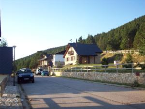 a car driving down a road next to a house at Port del Comte a pie de pistas in La Coma i la Pedra